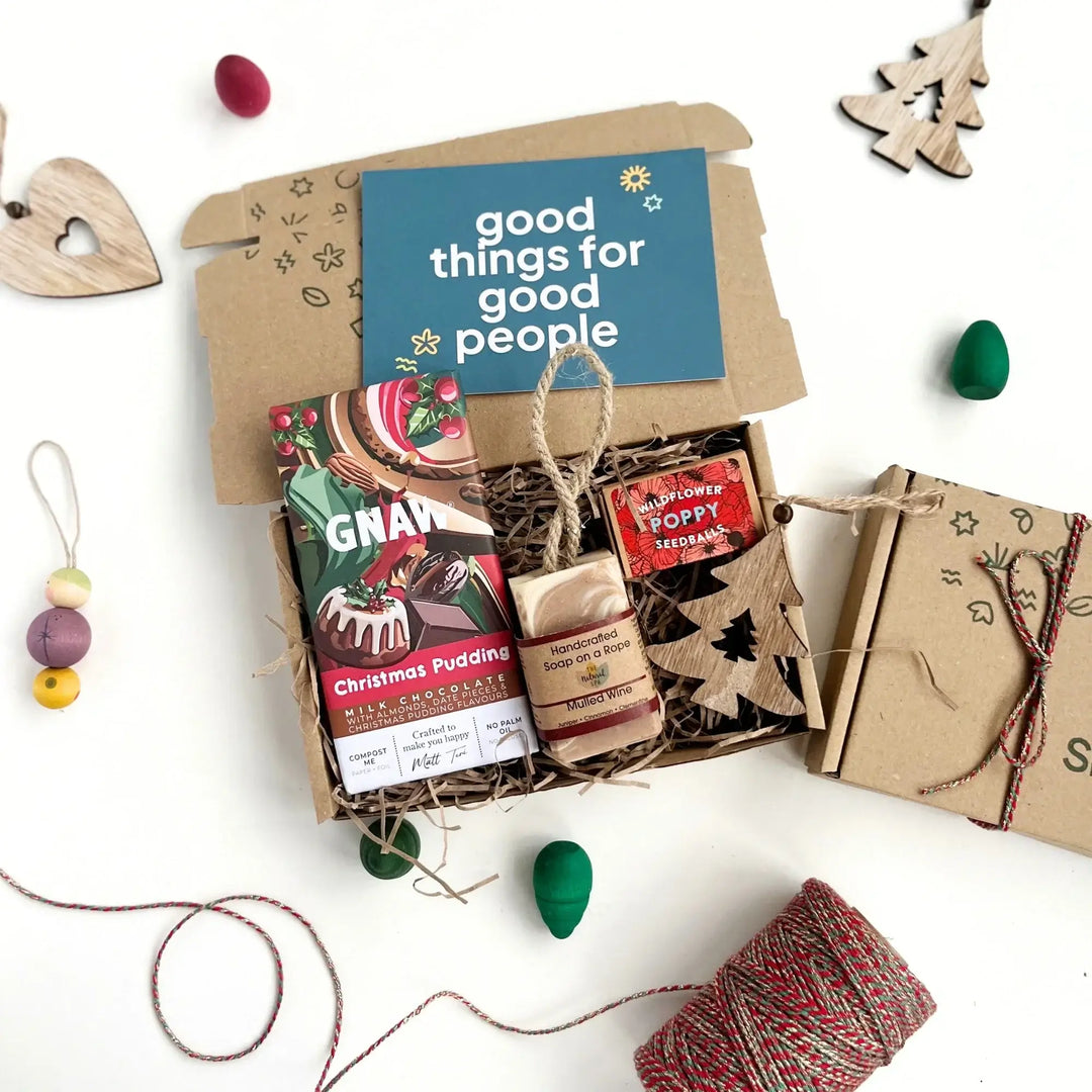 kraft gift box filled with Christmas themed products including a mulled wine soap bar, christmas pudding chocolate bar, poppy seeds and wooden decoration