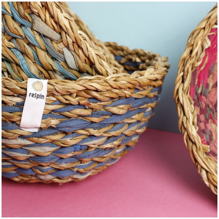 close up of colourful woven storage baskets on a pink surface 