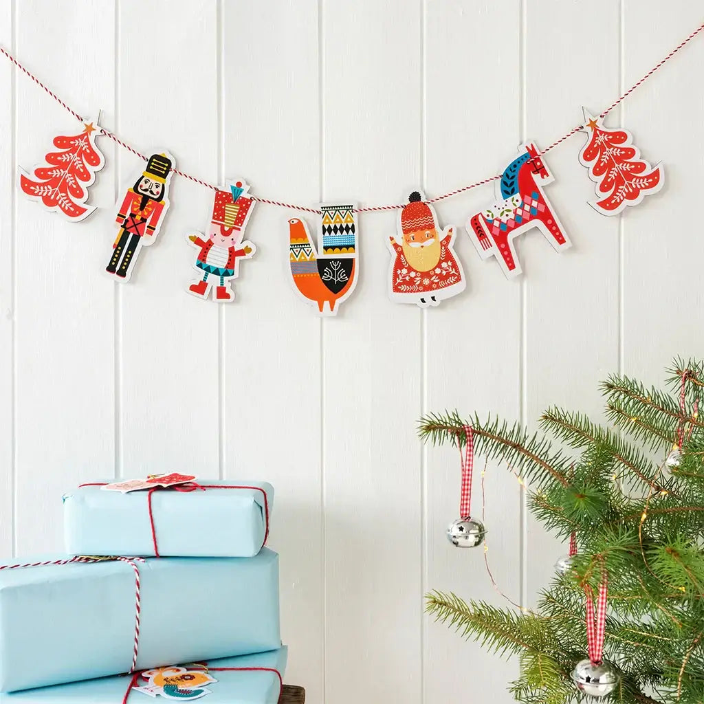 scandi inspired wooden Christmas garland hung on a white wall