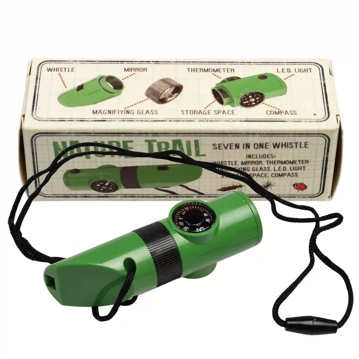 green hiking whistle for kids with a built in compass and a black lanyard. Nature themed packaging in the background. 