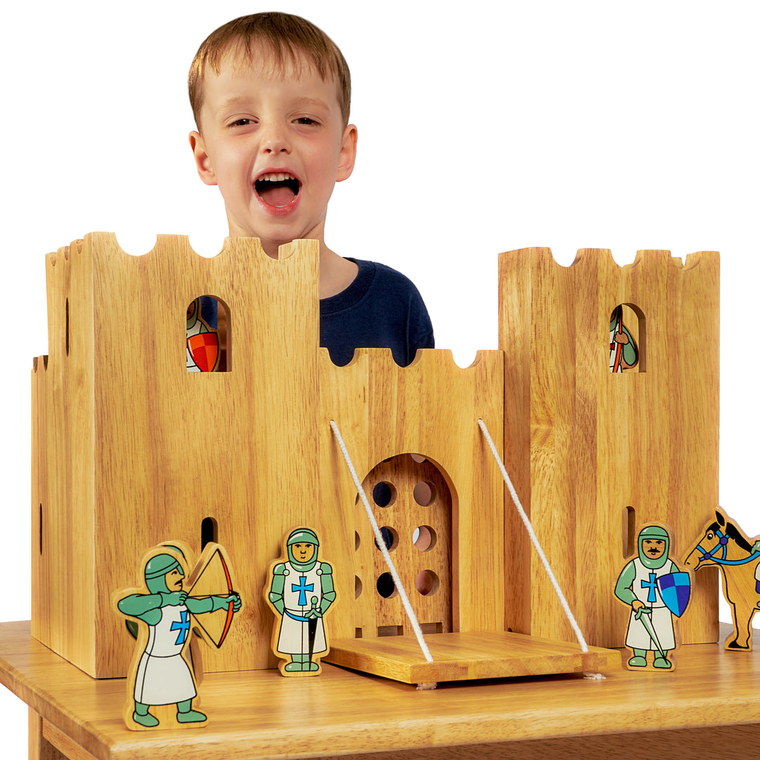 Wooden toy castle with knights and a child peeking through a window
