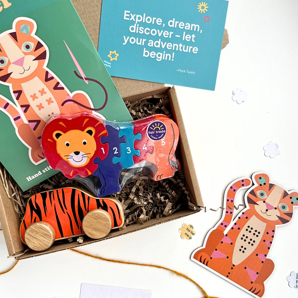close up of a kraft gift box with lion jigsaw puzzle, tiger learn to stitch kit and tiger themed wooden car. Gift for children age 3+