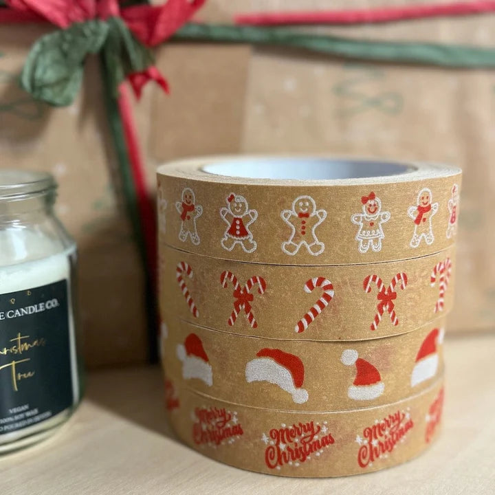 stack of four rolls of Christmas-themed tape s printed with gingerbread men, candy canes, and Santa hats on a neutral background.