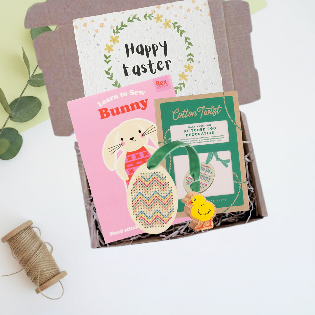 Easter-themed craft kit with a wooden chick and Happy easter card in a gift box on a white background