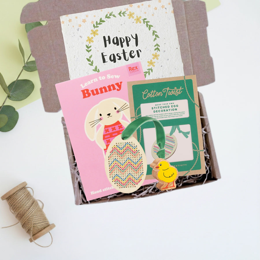 Easter-themed craft kit with a wooden chick and Happy easter card in a gift box on a white background