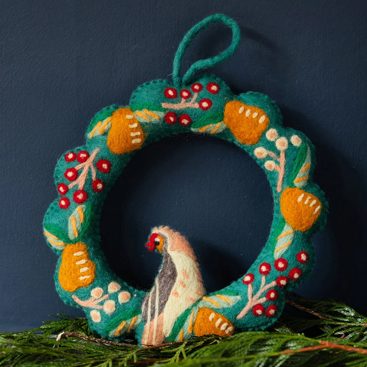 Decorative felt wreath with a bird design on a dark background
