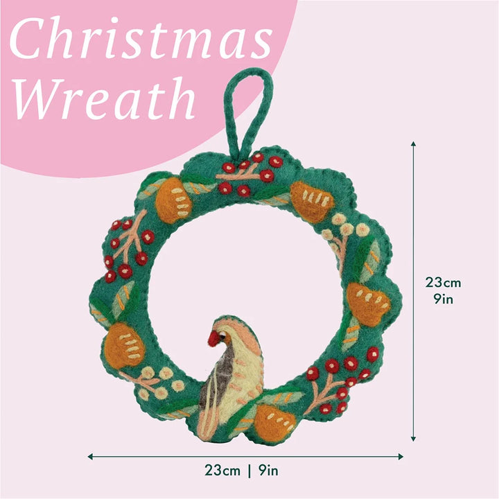 Christmas wreath with bird design and measurements on a pink background