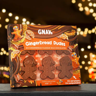 Packaging of Gingerbread Dudes chocolates in an orange and brown gift box with a festive background