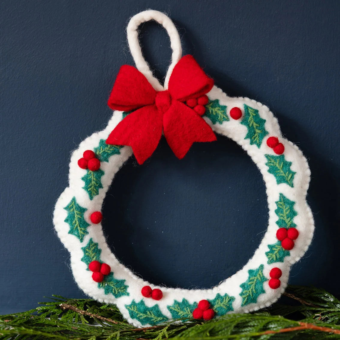 Decorative Christmas wreath with a red bow on a dark blue background