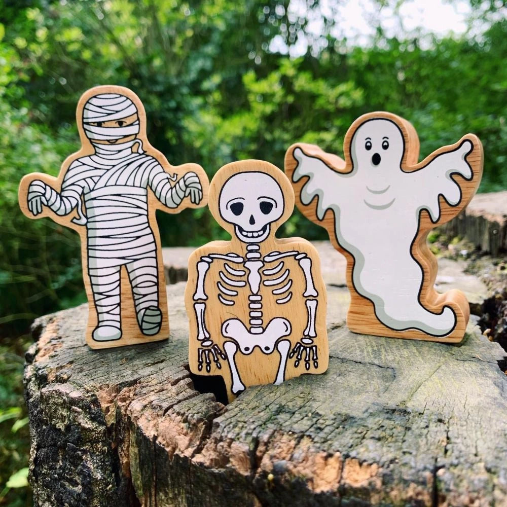 wooden skeleton, mummy and ghost play figures for children over 10 months. They feature painted details and a natural wood grain edge. 