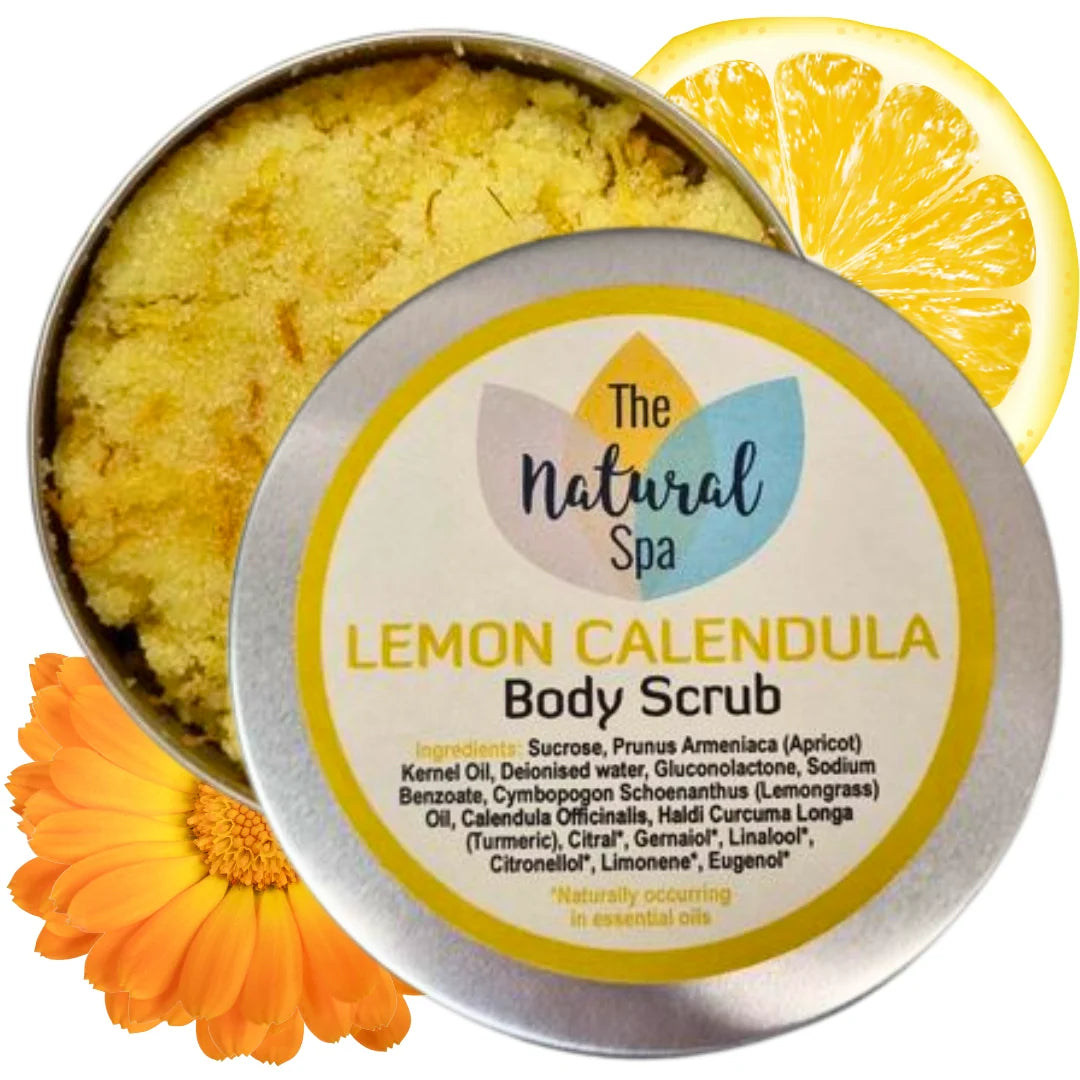 Lemon Calendula body scrub in a tin with a lemon slice and calendula flower on a white background