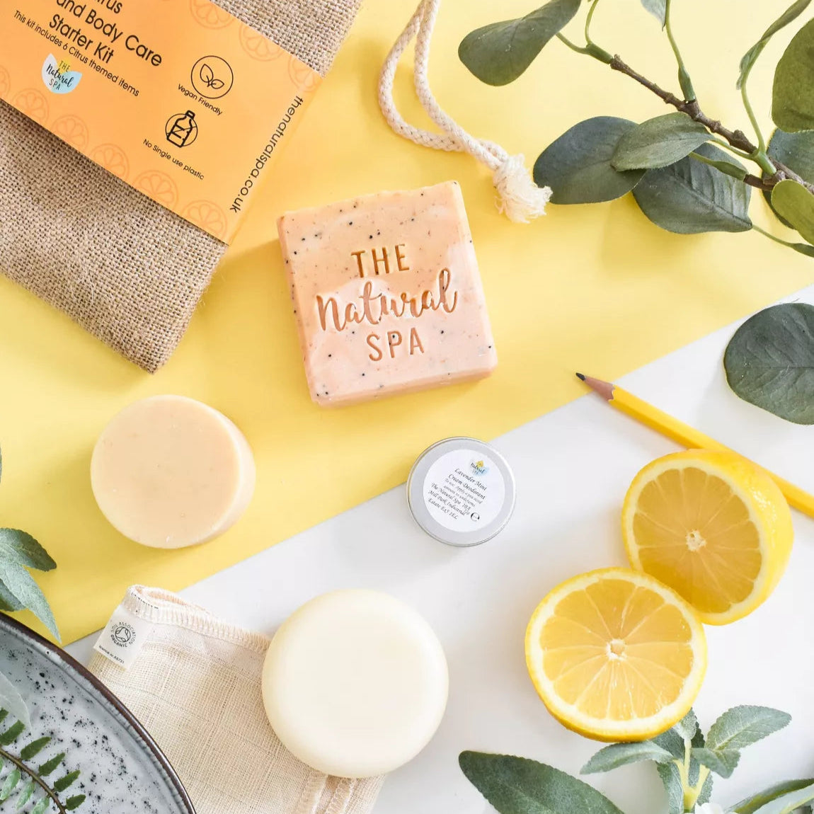 Overhead view of Natural Spa Citrus Hair and Body Starter Kit including shampoo bar, conditioner bar, soap bar, deodorant and wash cloth. 