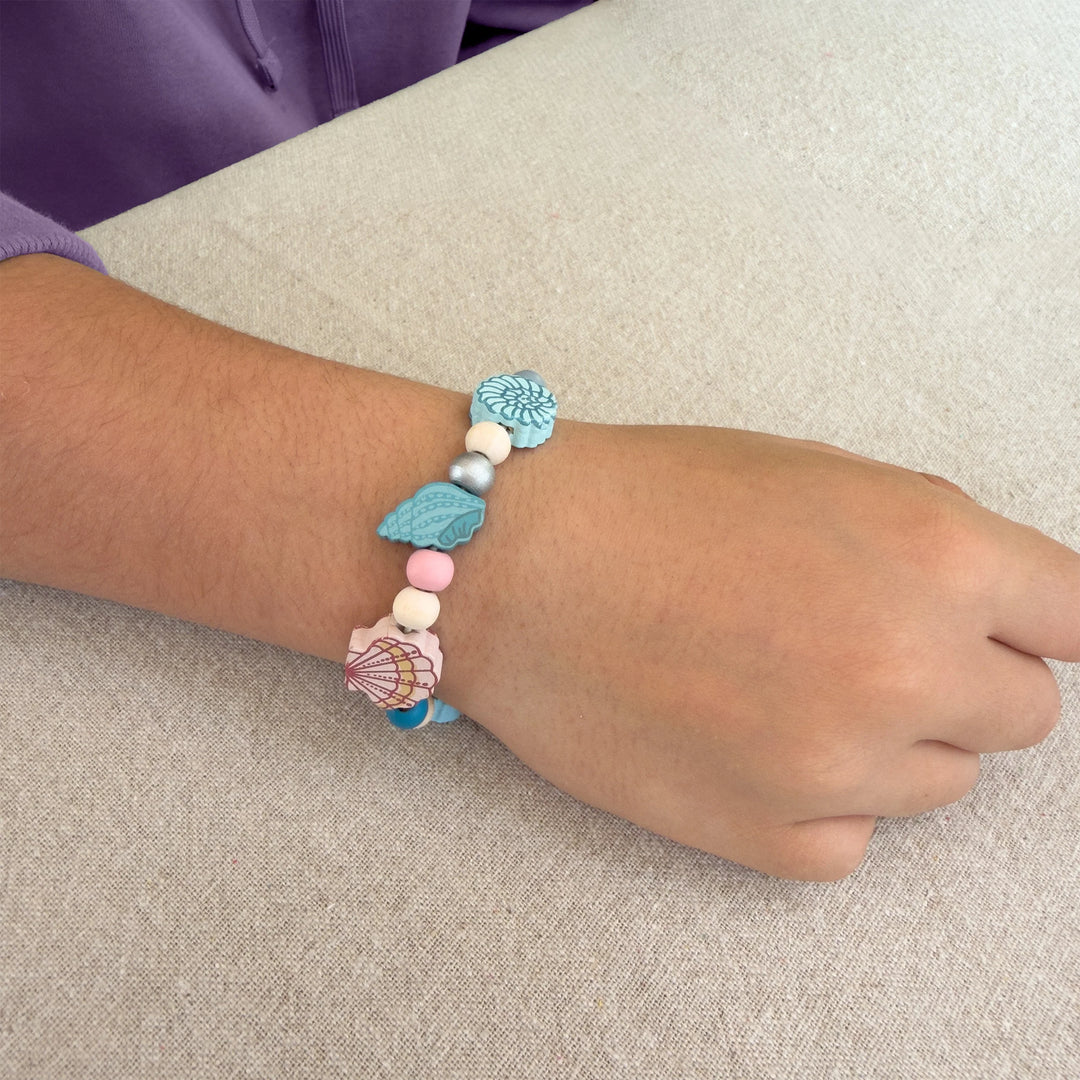 Bracelet with colorful beads on a wrist against a neutral background