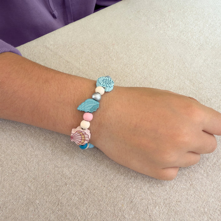 Bracelet with colorful beads on a wrist against a neutral background