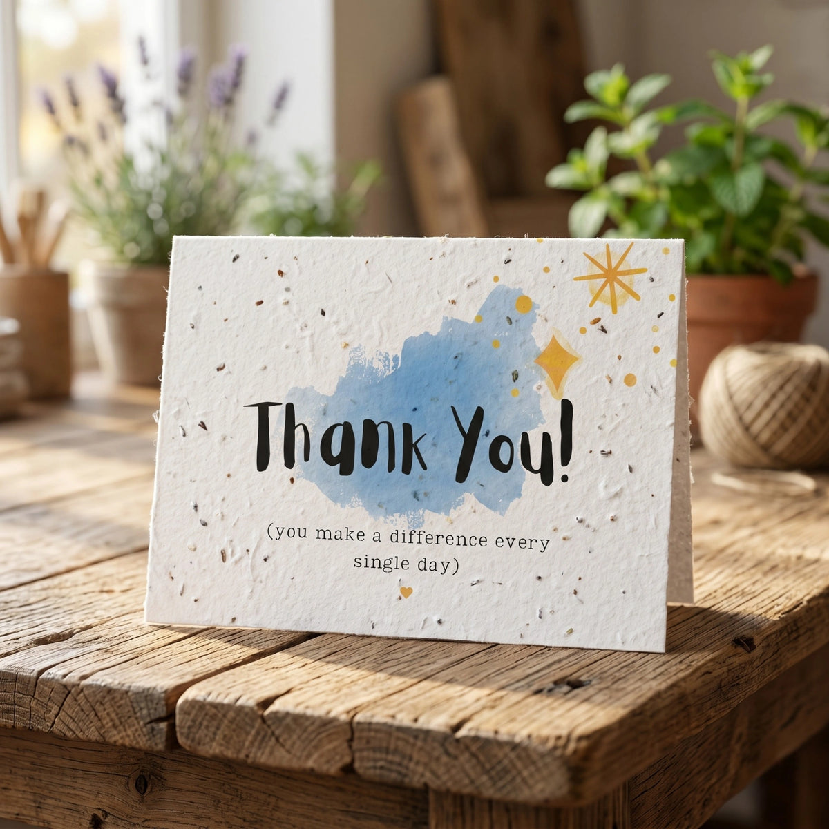Greeting card with 'Thank You!' message on a wooden surface with plants in the background
