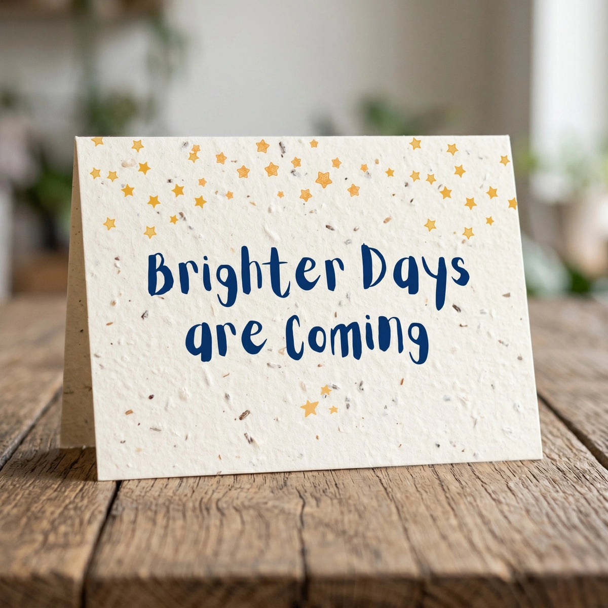 Greeting card with 'Brighter Days are Coming' text on a wooden surface