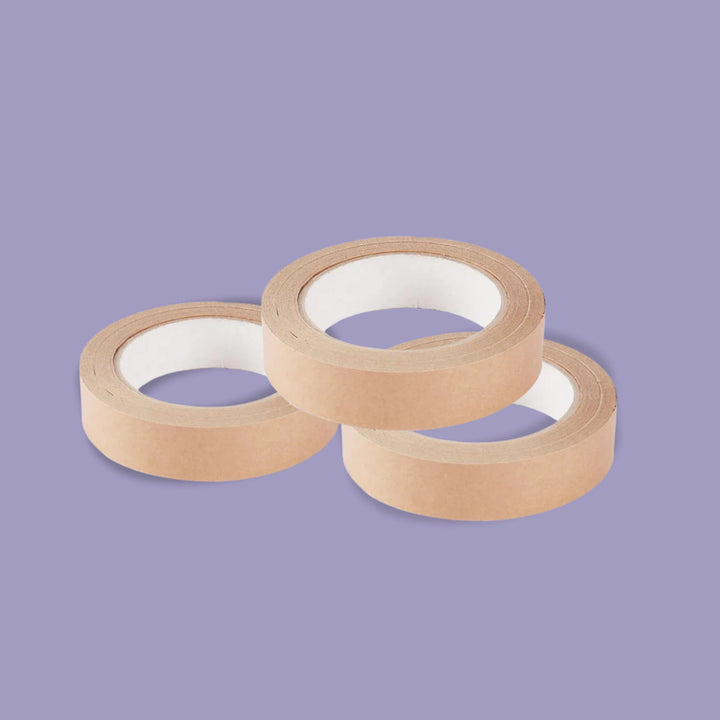 Three rolls of brown paper tape on a purple background