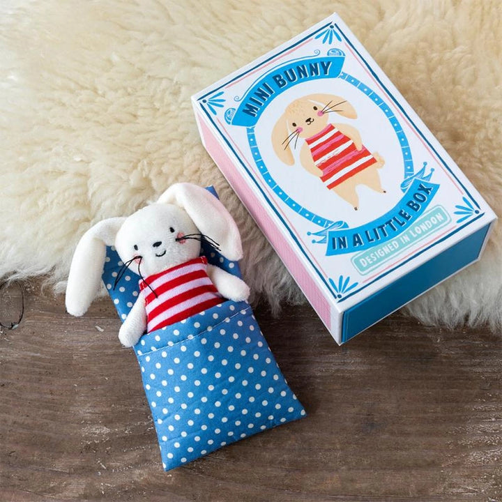 a white Bunny Soft Toy wearing a red stripe jumper with a blue and white polka dot bed. The bunny comes in a sliding gift box and is perfect for kids age 3 and over