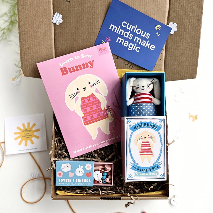 Children's craft gift box with bunny learn to sew kit, bunny toy, and jewellery making kit all inside a hand stamped gift box on a white background