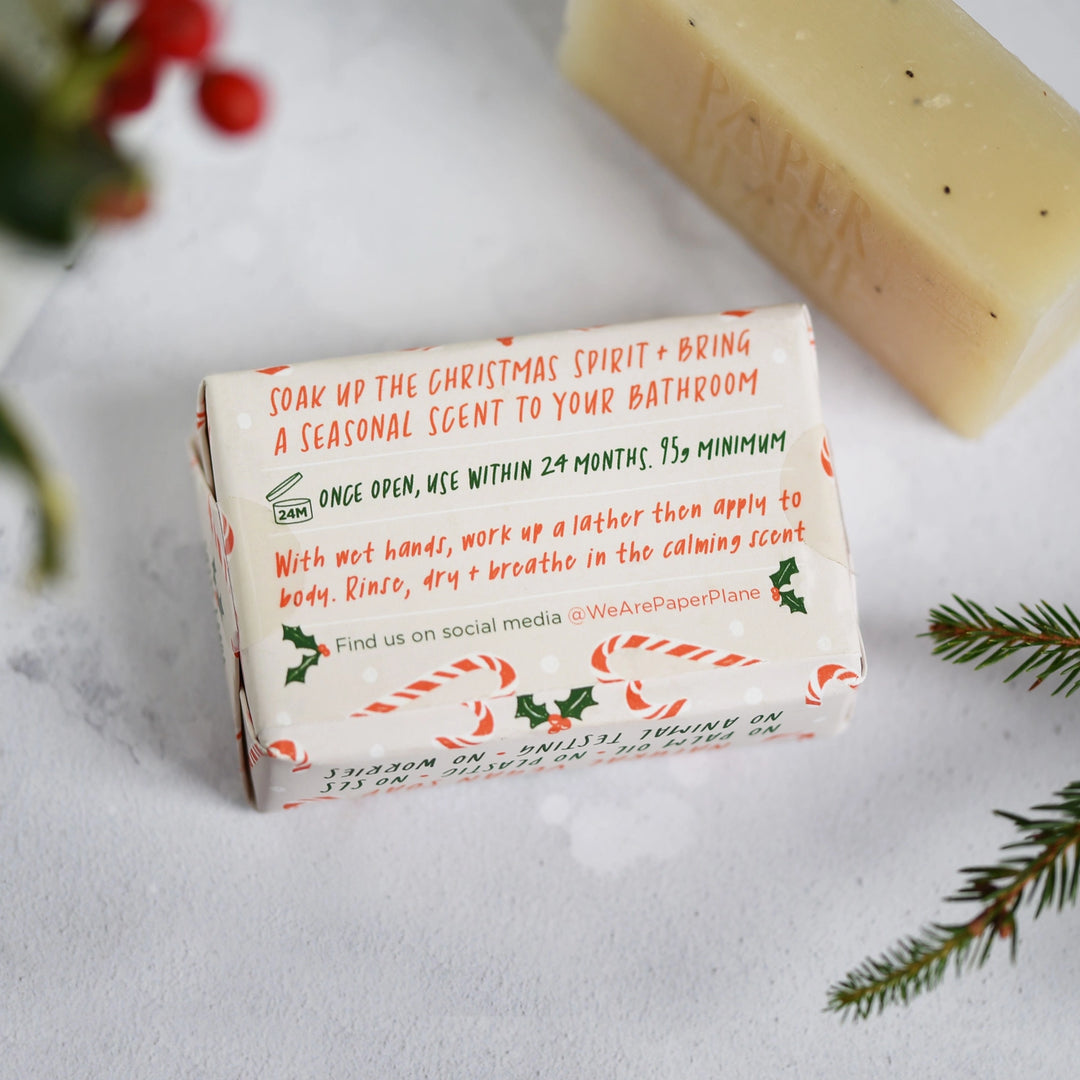 candy cane christmas soap bar packaging on a light background with holly leaves
