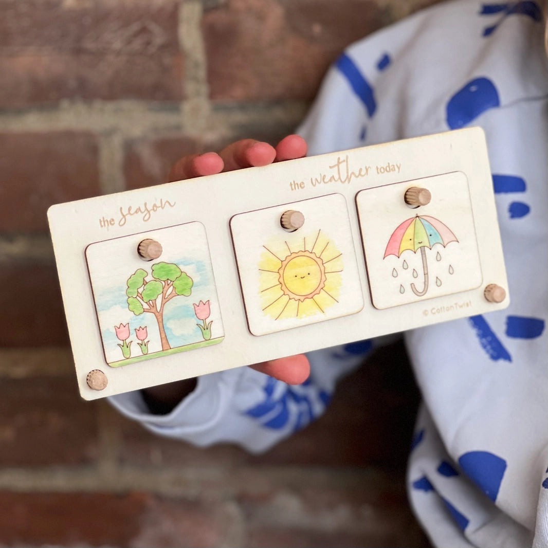 childs hands holding a wooden make your own weather chart by cotton twist
