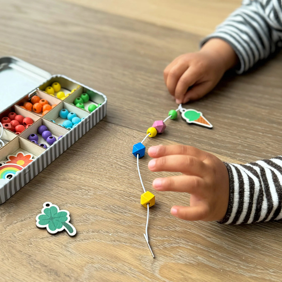 child stringing beads from the Cotton Twist Lucky Dip keyring Kit 
