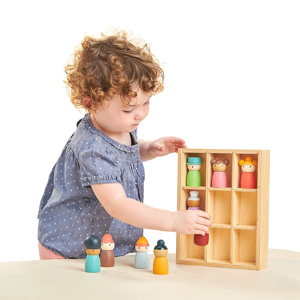 child playing with tender leaf happy folk hotel wooden toy. Nine wooden peg dolls with a hotel storage box. Age 3+