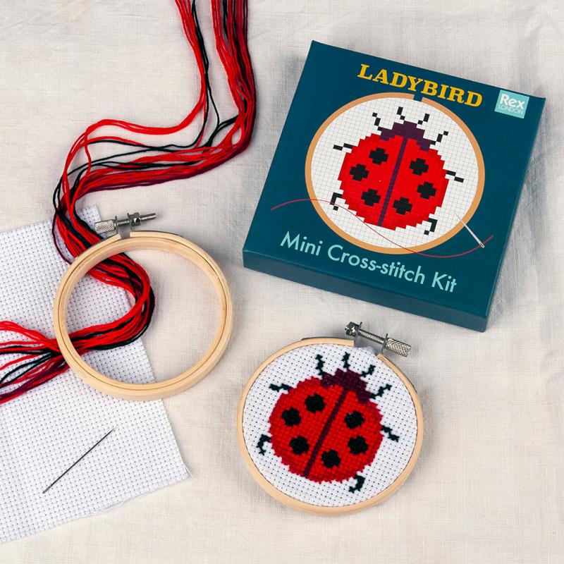 ladybird mini cross stitch kit on a table with gift box packaging
