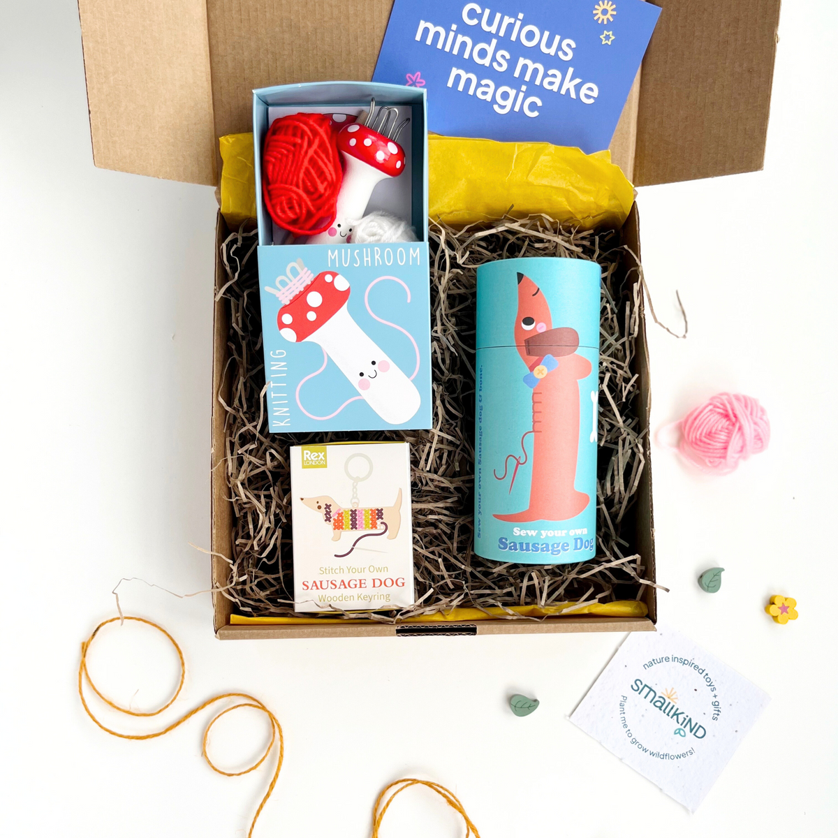 childrens sewing crafts gift box which includes a make your own keyring kit, sew your own sausage dog kit and a knitting mushroom with wool. The products are inside a hand stamped craft gift box with a gift card.