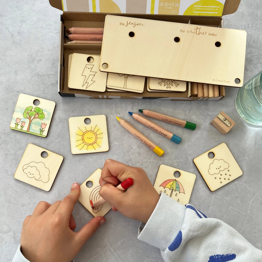 child colouring wooden tokens from the Cotton Twist Make Your Own Weather Chart kit 