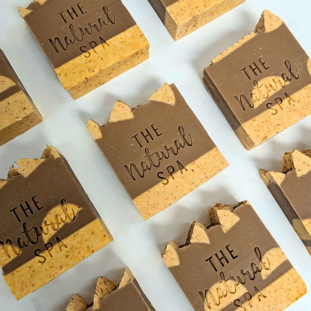 Multiple bars of soap from 'The Natural Spa' arranged on a white background