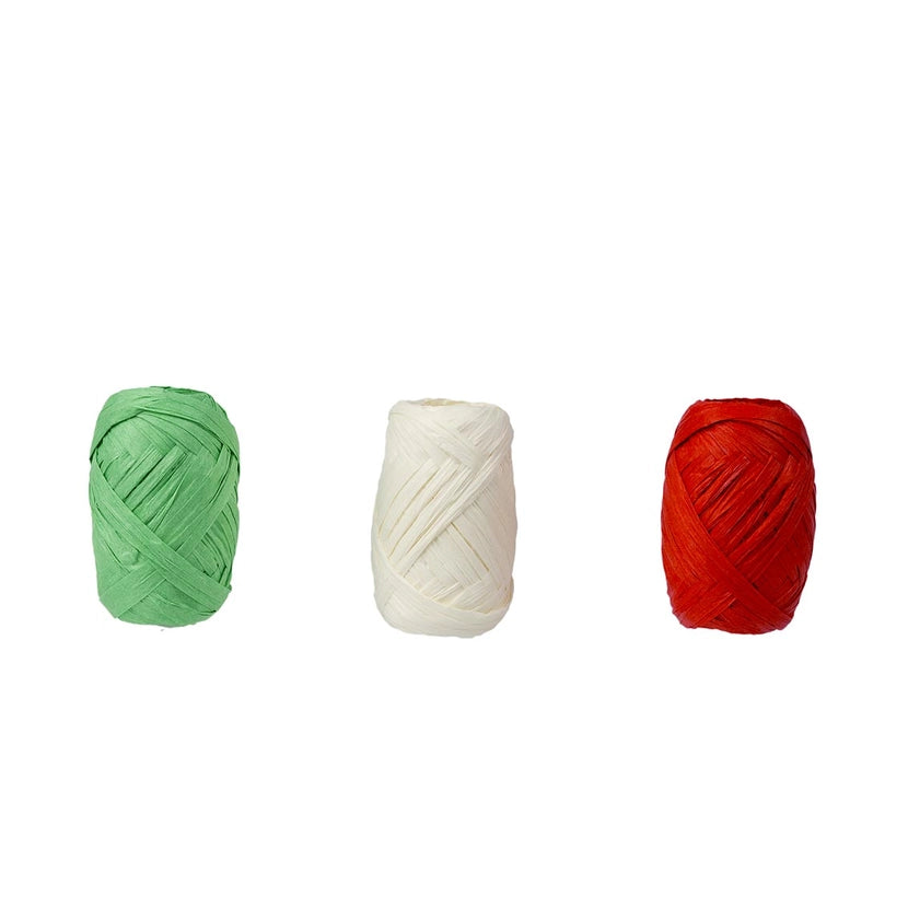 Three balls of raffia ribbon in green, white, and red on a white background