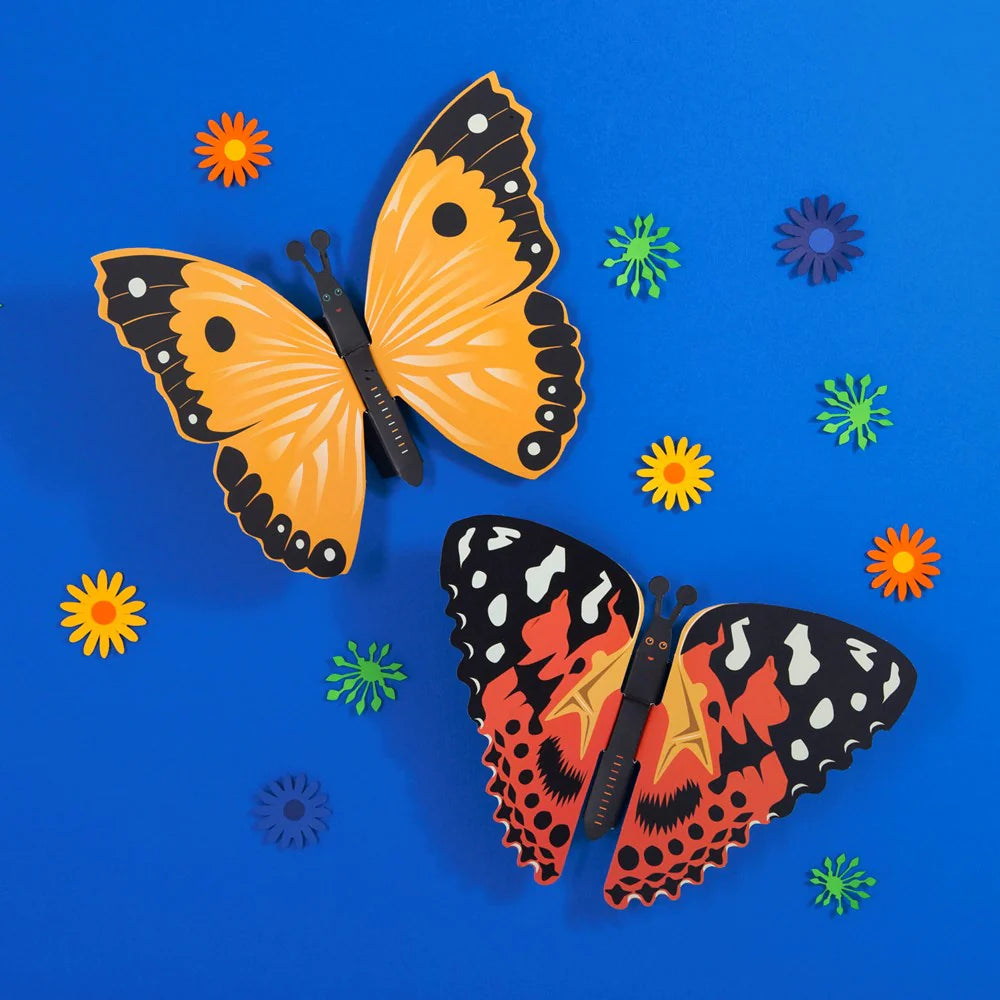 Create Your Own Fluttering Butterflies Craft Kit - finished paper butterflies displayed on a blue wall