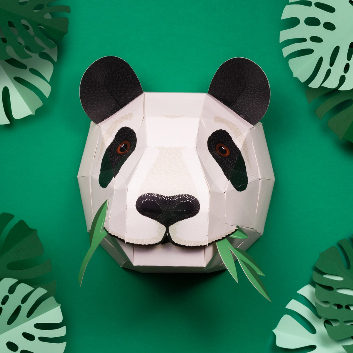 Create Your Own Giant Panda Craft Kit, finished panda head with green leaves hung on a green wall