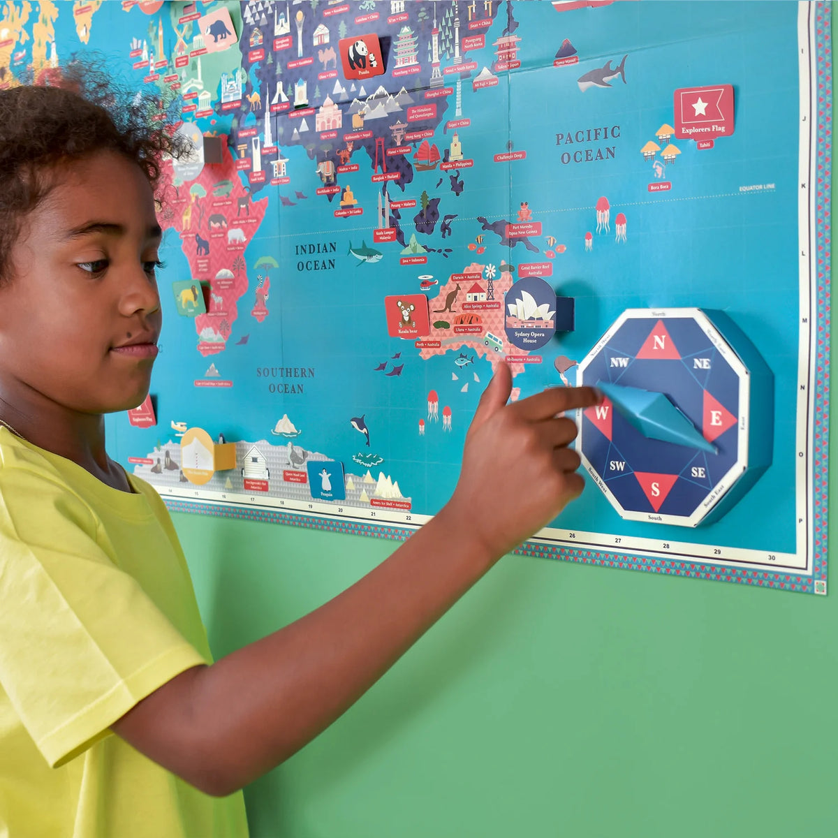 close up of girl with Clockwork Soldier Create Your Own Giant World Map kit on a green wall