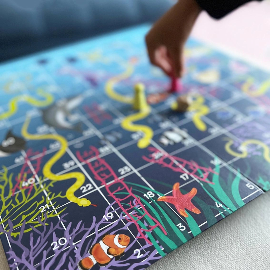 Colorful board game with snakes and ladders on a blue mat