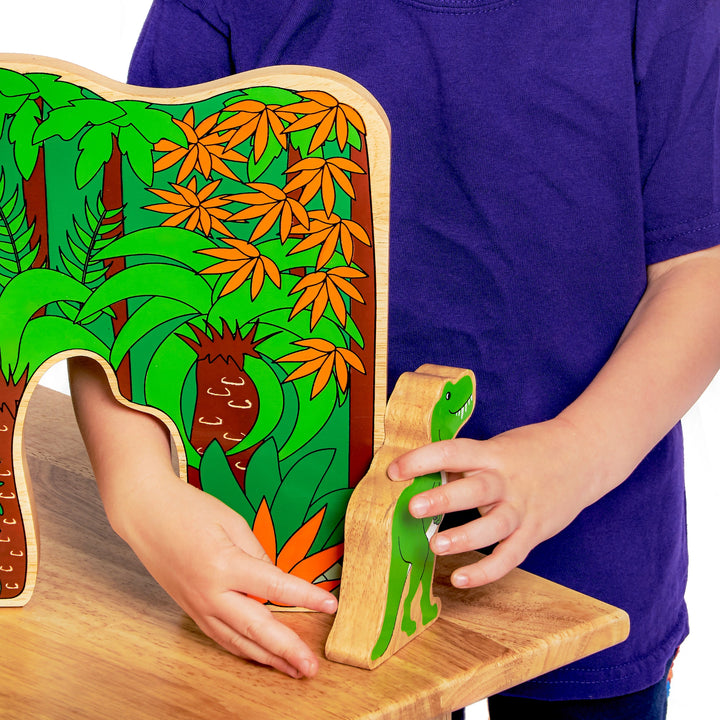 Child playing with a wooden toy set featuring a green dinosaur and a colourful jungle scene.