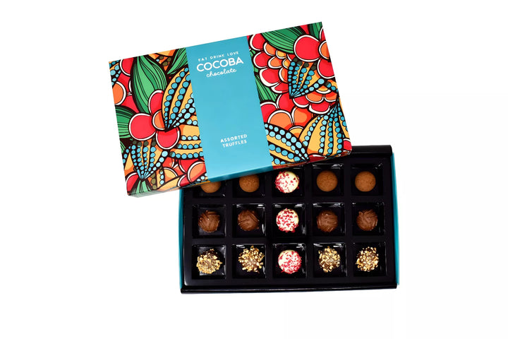 Colourful box of chocolate truffles with a decorative lid on a white background