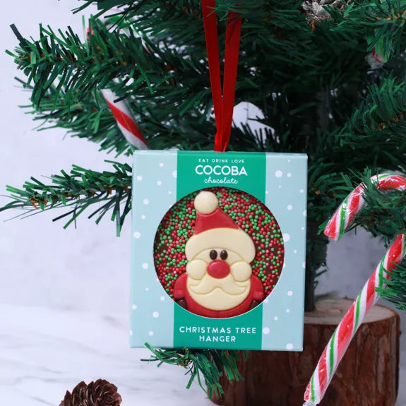 Milk chocolate Christmas tree hanger with a Santa Claus design, hung on a small Christmas tree.