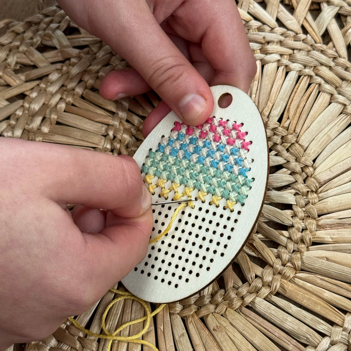 child's hands stitching a make your own stitched egg decoration 