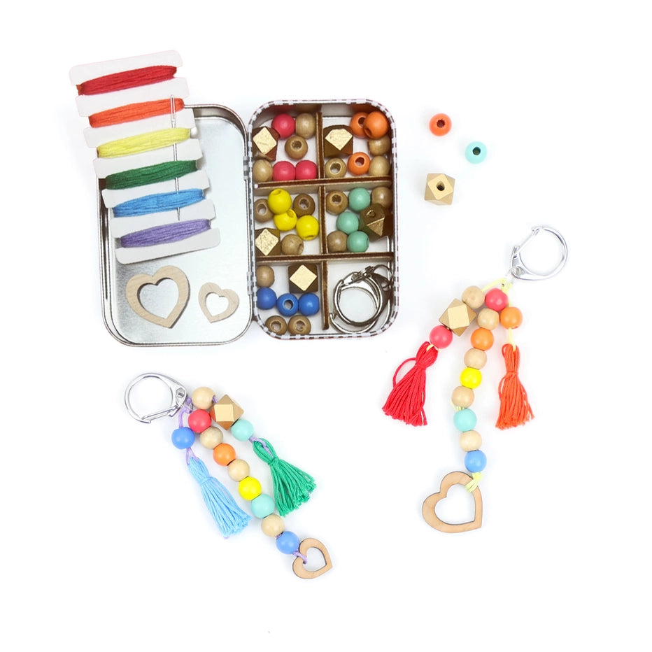 Colourful beaded keychains with beads, threads and keyring components on a white background