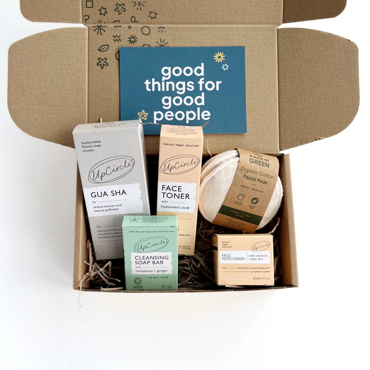 deluxe natural skincare gift box including facial toner, organic cotton facial rounds, face moisturiser, stainless steel gua sha tool and facial cleansing bar. The products are in a kraft gift box with shredded paper and hand stamped details. Includes a card which reads 'good things for good people'.