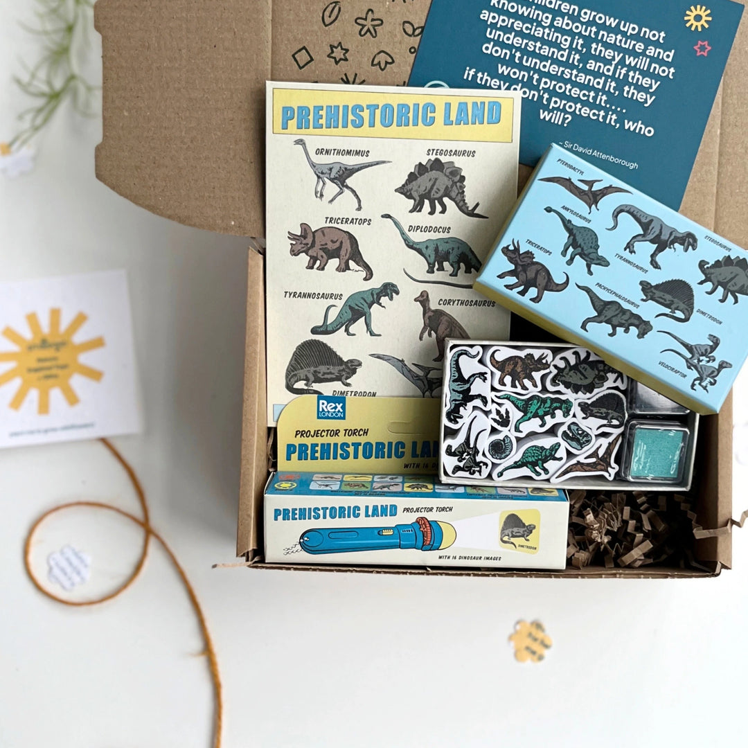 Prehistoric-themed educational kit with stamps, torch, and temporary tattoos on a white surface.