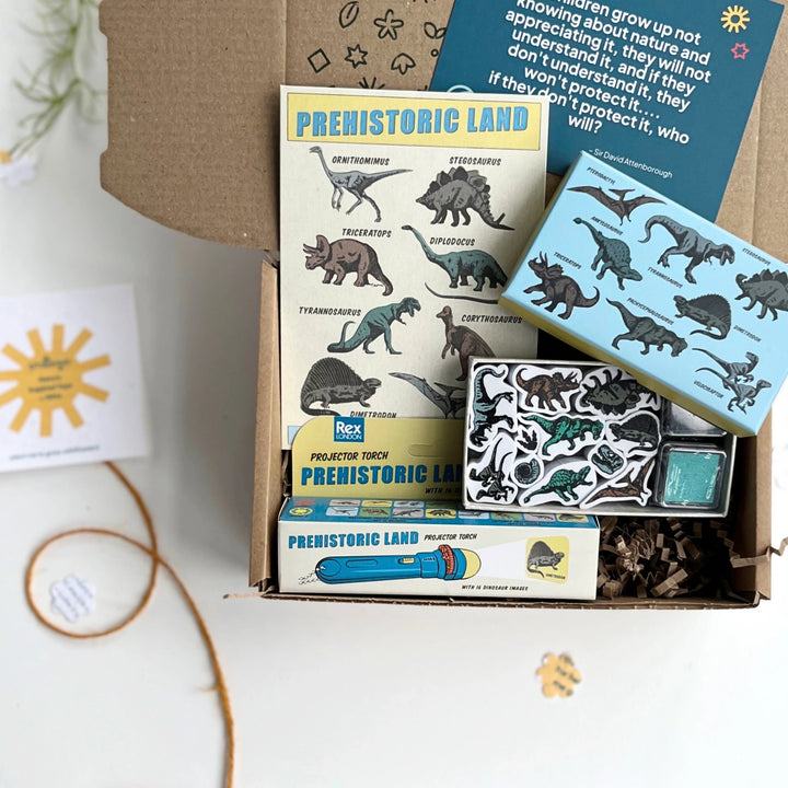 Prehistoric-themed educational kit with stamps, torch, and temporary tattoos on a white surface.