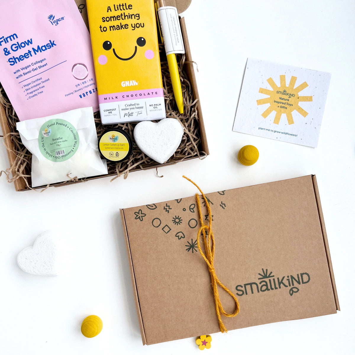 close up of a hand stamped smallkind gift box tied with yellow twine. The 'don't stress' gift box is in the background