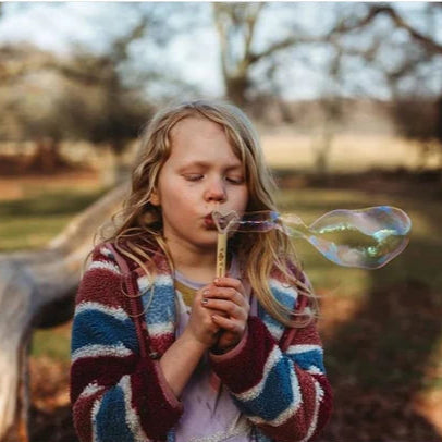 child blowing bubbles with the Dr Zigs mini bubble wand 