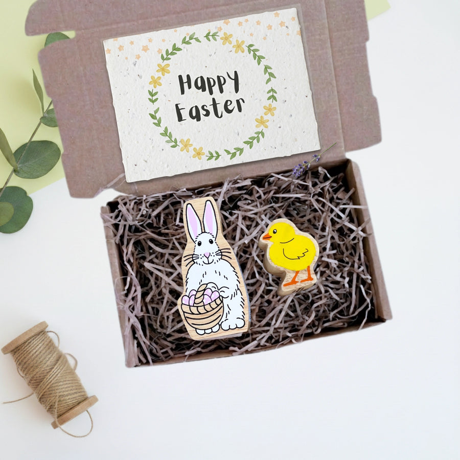 Easter-themed wooden pins in a box with a 'Happy Easter' card on a light background