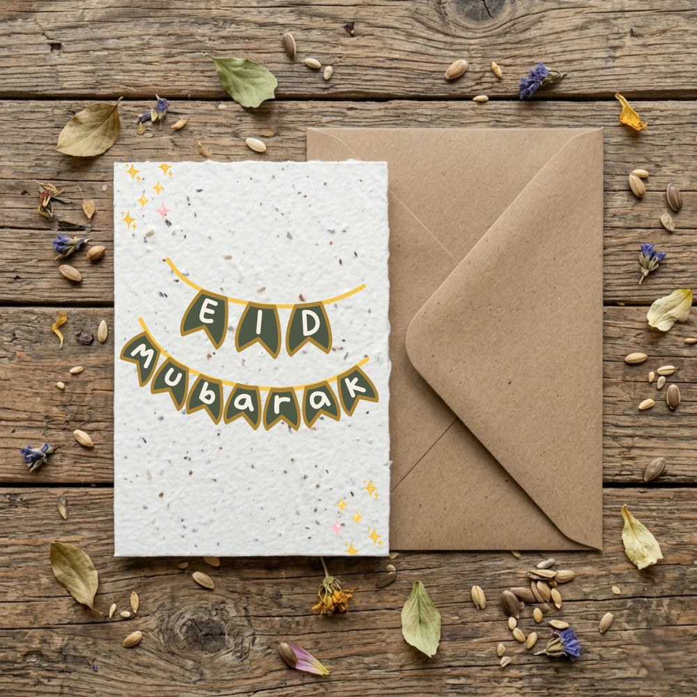 Eid Mubarak card with envelope on a wooden surface with dried leaves and seeds.