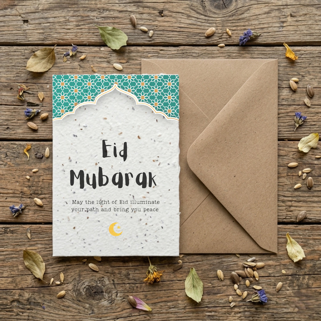 Eid mubarak card with green details and a kraft envelop on a wooden surface 