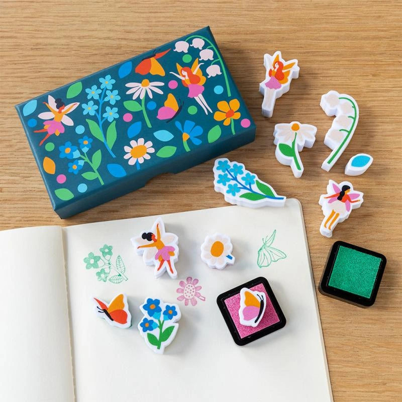 Colourful fairy mini stamp set with fairy and floral designs on a wooden surface.